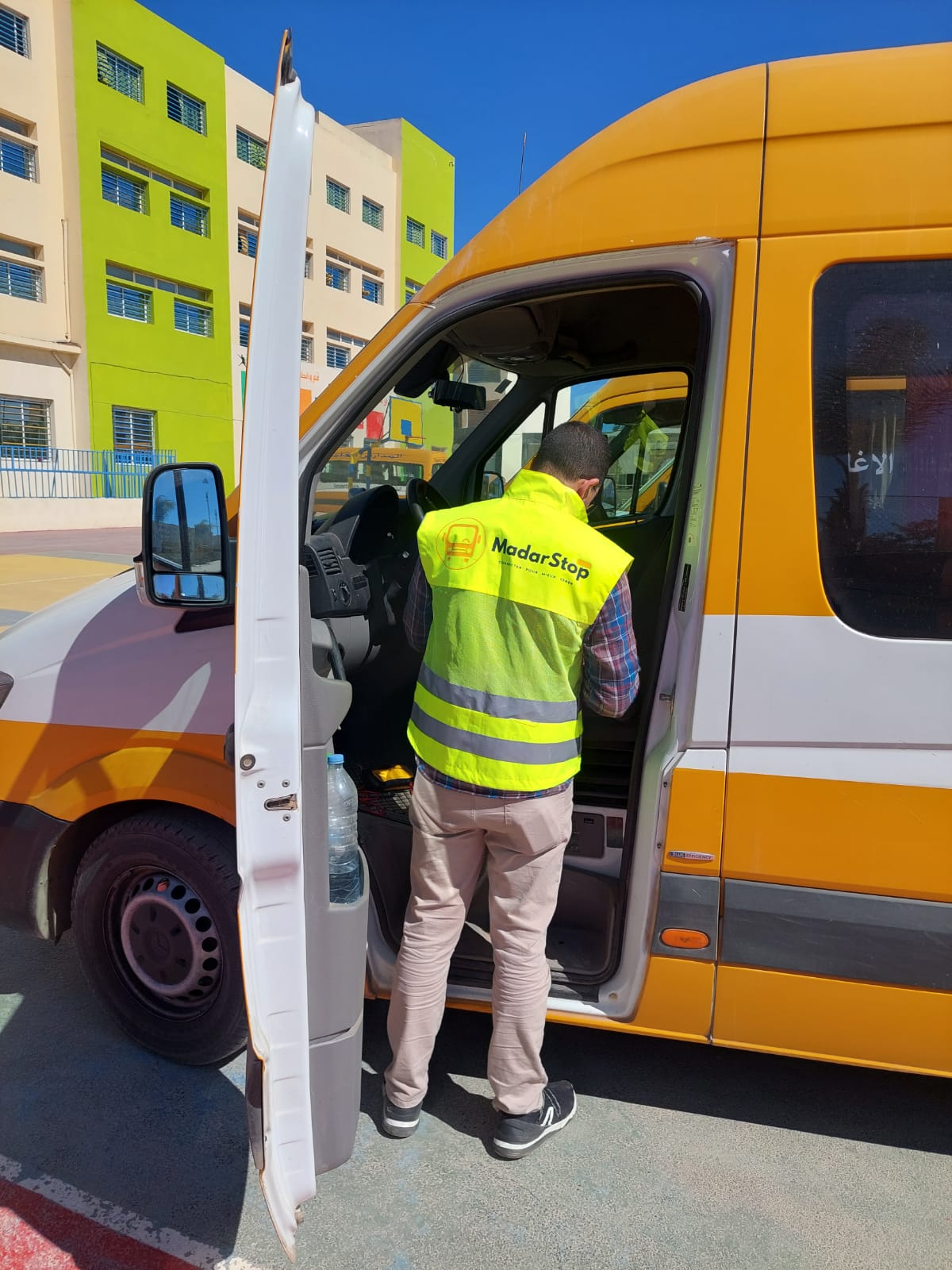 Technicien MadarStop installant un GPS dans un bus scolaire